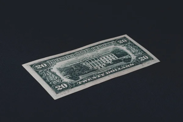 Close up of twenty dollars lie on the back on a black background. — Stock Photo, Image