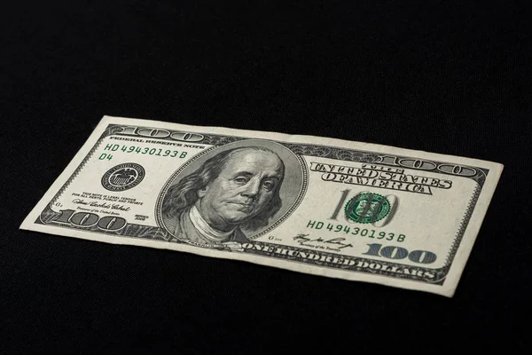 Сто американских долларов лежат на черном фоне, свободное место для надписи . — стоковое фото