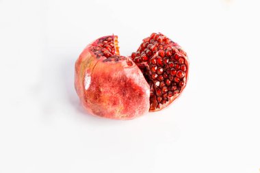 Beyaz arka planda izole edilmiş olgun nar meyveleri, dilimlenmiş meyve..