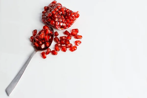 Frutos de granada y semillas de granada en cuchara sobre fondo blanco . —  Fotos de Stock