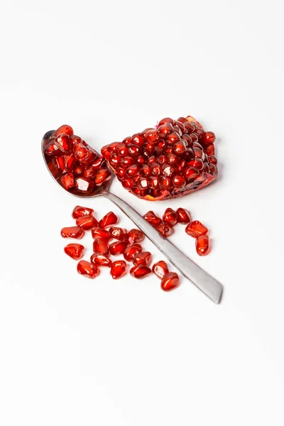 Frutos de granada y semillas de granada en cuchara sobre fondo blanco . —  Fotos de Stock