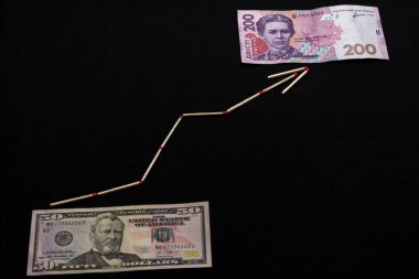 Siyah arka planda oklu Ukrayna Hryvnia ve Amerikan doları.