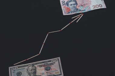 Siyah arka planda oklu Ukrayna Hryvnia ve Amerikan doları.