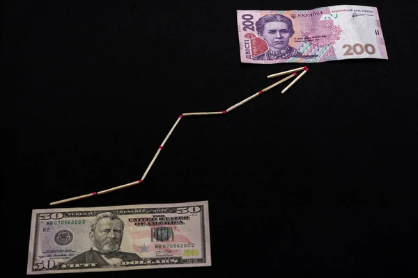 Oekraïense hryvnia en Us dollar met pijl op zwarte achtergrond. — Stockfoto