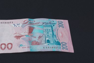 Ukrainian two hundred hryvnia lie on the back on a black isolated background.