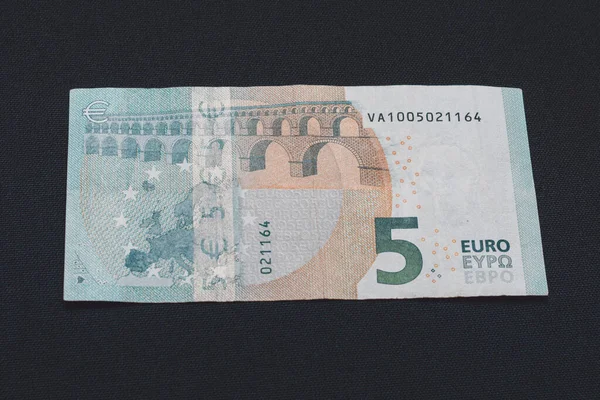 Detal banknotu 5 euro z hologramami przeciwdziałającymi podrabianiu, ostrość wybiórcza, czarne tło, jeden banknot. — Zdjęcie stockowe