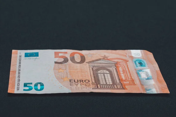 Pięćdziesiąt euro denominowanych w euro papierowych pieniędzy na czarnym tle. — Zdjęcie stockowe