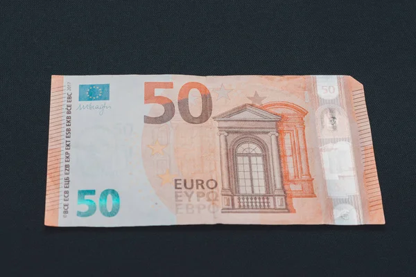 Fifty euro denominated paper money on a black background. — ストック写真