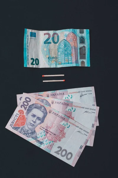 Euro en hryvnia, bankbiljetten op zwarte achtergrond. — Stockfoto