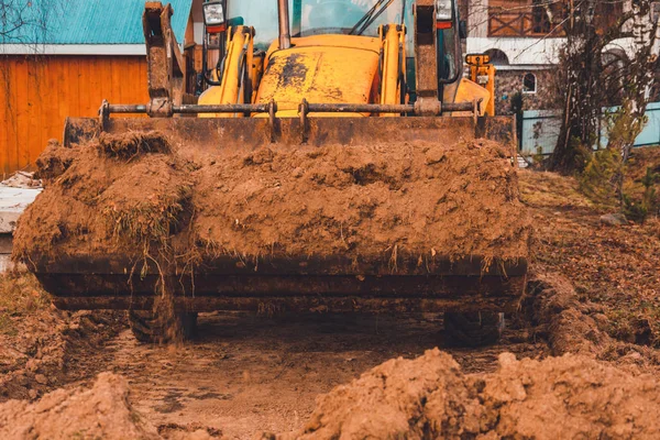 A escavadora trabalha na rua do campo, na construção de estradas . — Fotografia de Stock