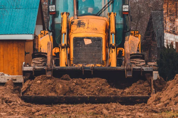 Gros plan d'une grande excavatrice à godet creusant le sol pour mettre la route . — Photo