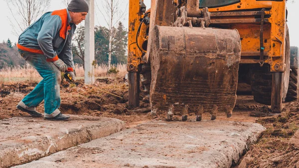 A escavadora instala lajes de concreto para a estrada . — Fotografia de Stock