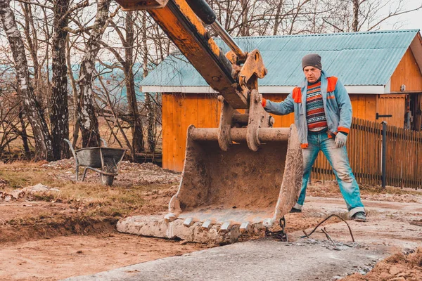 Uma escavadora de corrente puxa lajes de concreto para definir a pista . — Fotografia de Stock