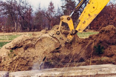 Kazıcı, özel bölgede yolu açmak için beton levhaları hareket ettiriyor..
