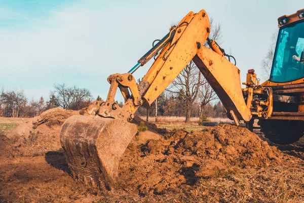 De graafmachine ontruimt de grond om de weg in privaat gebied te plaveien. — Stockfoto