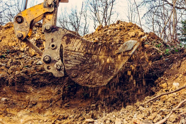 Fondo de cubo de excavadora con suelo en el bosque y el fondo del cielo . —  Fotos de Stock