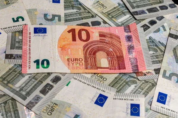 Billetes en euros, textura de 5 y 10 euros, diez euros superan los cinco euros . — Foto de Stock