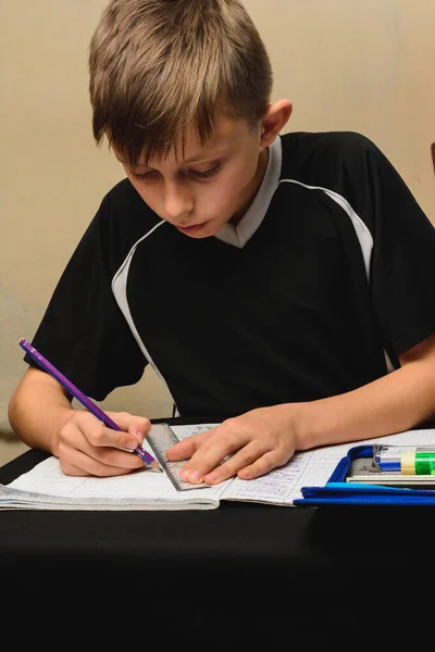 Pequeno estudante entediado lição de casa em um caderno da escola para desenhar . — Fotografia de Stock