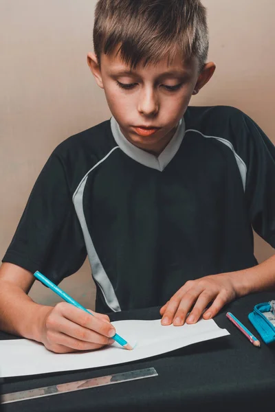 Um estudante desenha lápis em papel branco . — Fotografia de Stock