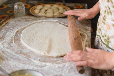 Evde bir kadın hamur işi yapıyor..
