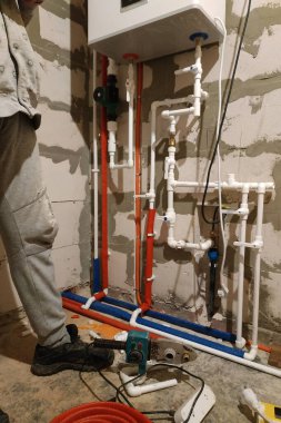 İşçi döşeme ısıtması için boru döşeme üzerinde çalışıyor.
