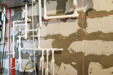 İşçi döşeme ısıtması için boru döşeme üzerinde çalışıyor.