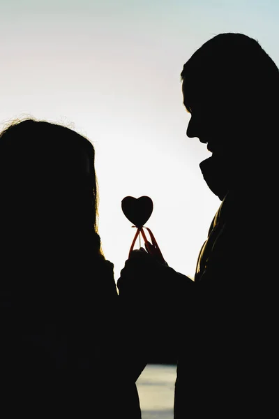 Silhouettes of boyfriend and girlfriend at sunset.