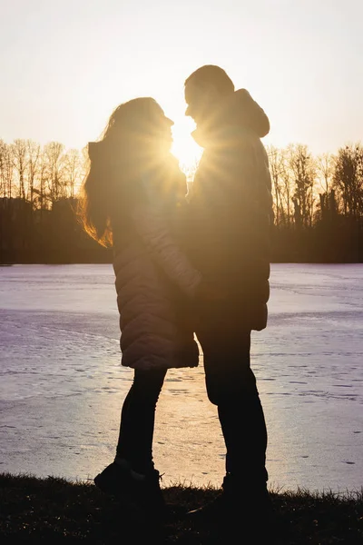 Silhuetas de namorado e namorada ao pôr do sol . — Fotografia de Stock