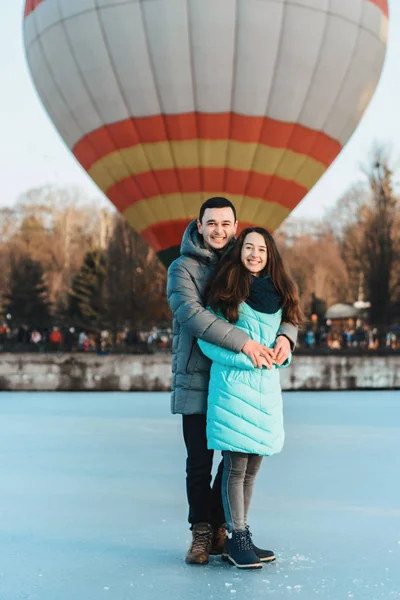 Liebespaar steht am Valentinstag auf dem Eis, hinter dem Luftball. — Stockfoto