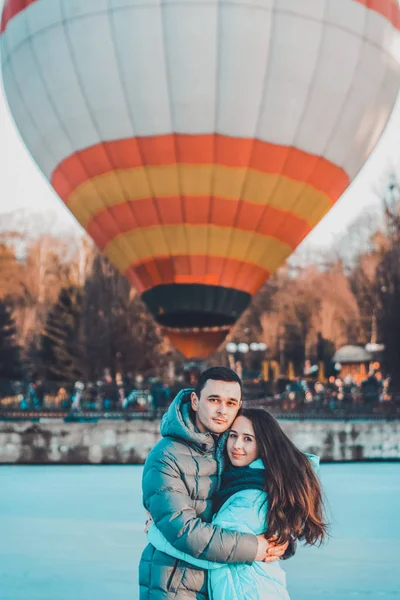 Älskade par står på is på Alla hjärtans dag, bakom luftbollen. — Stockfoto