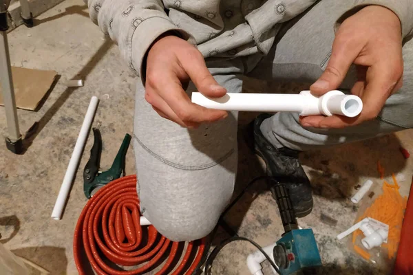 El trabajador soldó dos tubos para calentar el suelo con un soldador . — Foto de Stock