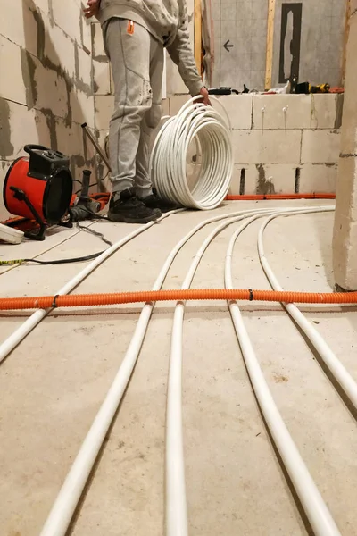Installation of tubes on the floor to heat it, bringing the tubes to the collector. — Stock Photo, Image