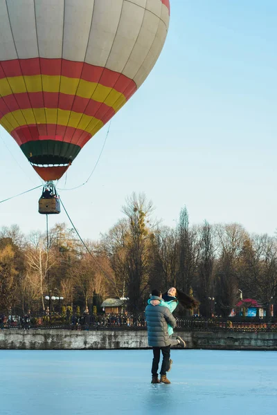 Brautpaar vor dem Hintergrund eines zugefrorenen Sees und eines Ballons, der in einem Stadtpark fliegt. — Stockfoto