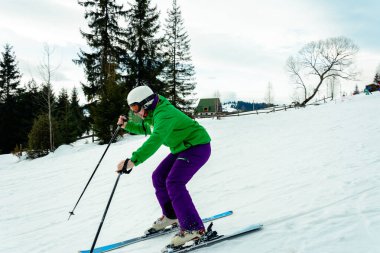 Yeşil ceket ve mor pantolon kayak genç adam.