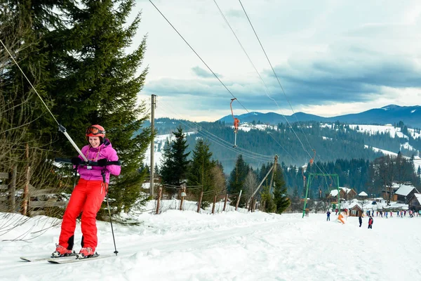 一个女人正在滑雪，爬山下滑雪道. — 图库照片