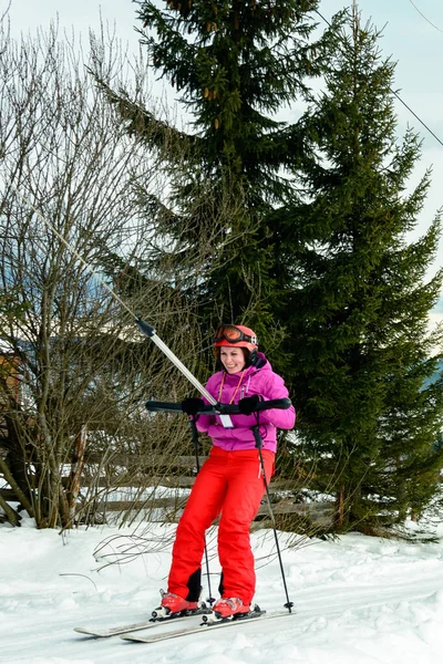 Eine Frau fährt Ski und klettert den Hügel hinauf, um die Skipiste hinunter zu gehen. — Stockfoto