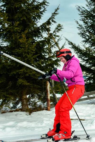 Eine Frau fährt Ski und klettert den Hügel hinauf, um die Skipiste hinunter zu gehen. — Stockfoto