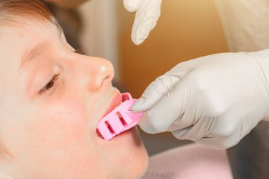 Çocuk ortodontist tabağa uygun bir şeyler hazırlıyor..