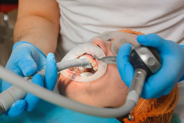A fogorvos ultrahanggal távolítja el a fogkövet.. — Stock Fotó