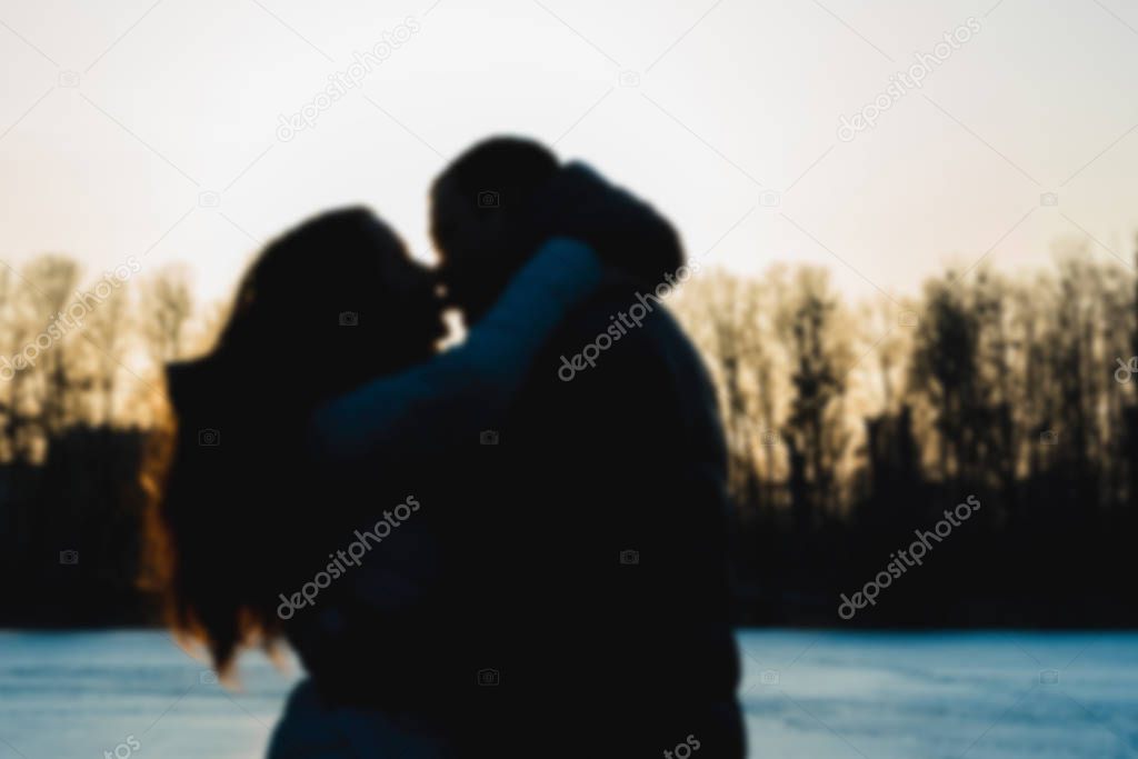 Silhouettes of boyfriend and girlfriend at sunset.