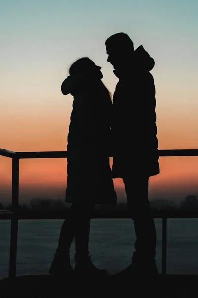 Silhouetten van vriend en vriendin bij zonsondergang. — Stockfoto