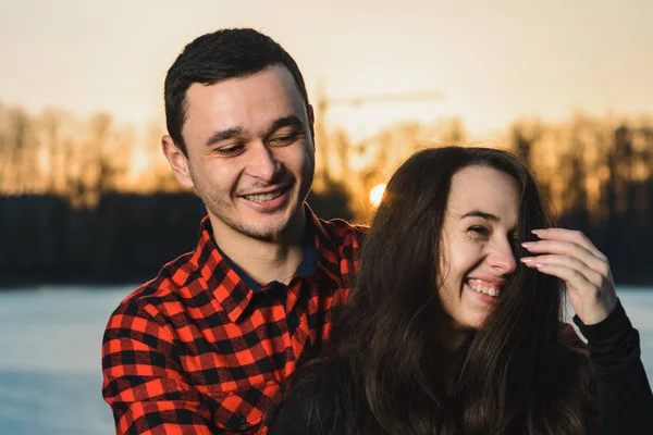 De man en het meisje in het park staan op Valentijnsdag op het ijs van het meer.. — Stockfoto