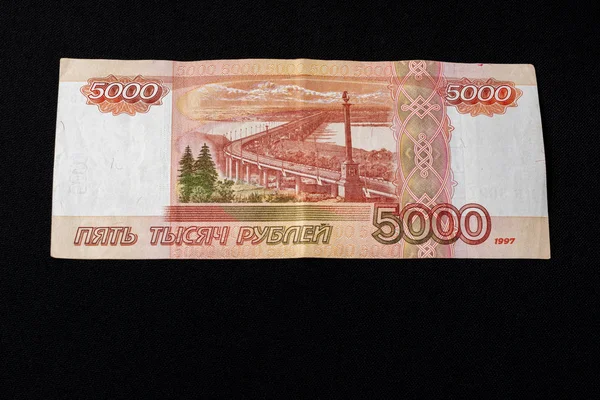 One Russian bill in the amount of 5000 rubles lies on the back on a black background. — Stock Photo, Image