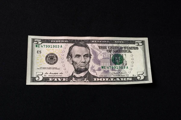 On the black background is one bill in size five dollars. — Stock Photo, Image