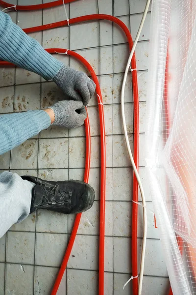 El maestro puso tubos en el suelo para calefacción y calefacción por suelo radiante . — Foto de Stock