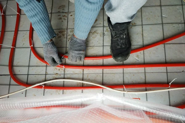 The master laid pipes on the floor for heating and floor heating. — 스톡 사진