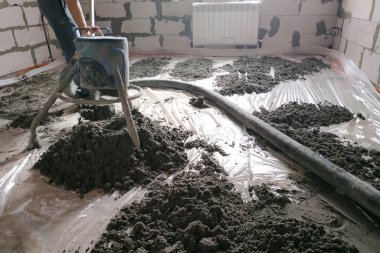 Construction site - machine floor screed, pipes for heating and floor heating.