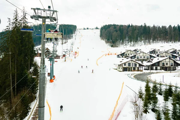 Bukovel, Ουκρανία 3 Φεβρουαρίου 2019: Ξενοδοχειακά συγκροτήματα με φόντο τα γραφικά Καρπάθια του χειμώνα, τουρίστες στο Bukovel, Ουκρανία. — Φωτογραφία Αρχείου