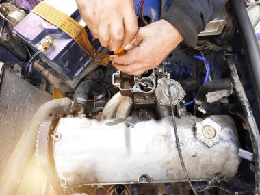 The auto locksmith tightens the valves of the in the garage.