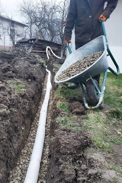 근로자는 집 주변의 물을 배수하기 위해 배수 작업을 수행. — 스톡 사진